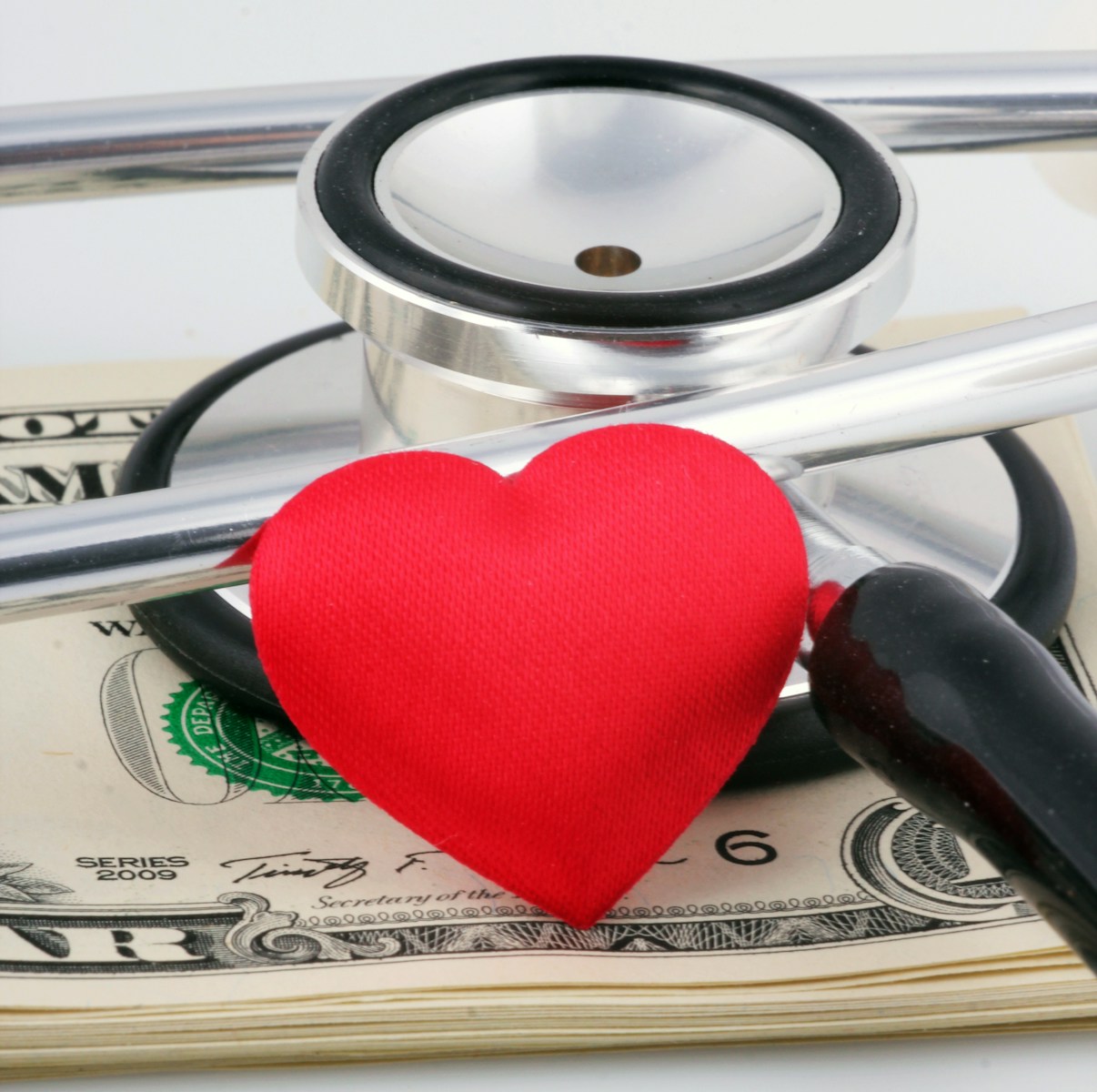a stethoscope and a heart on top of money