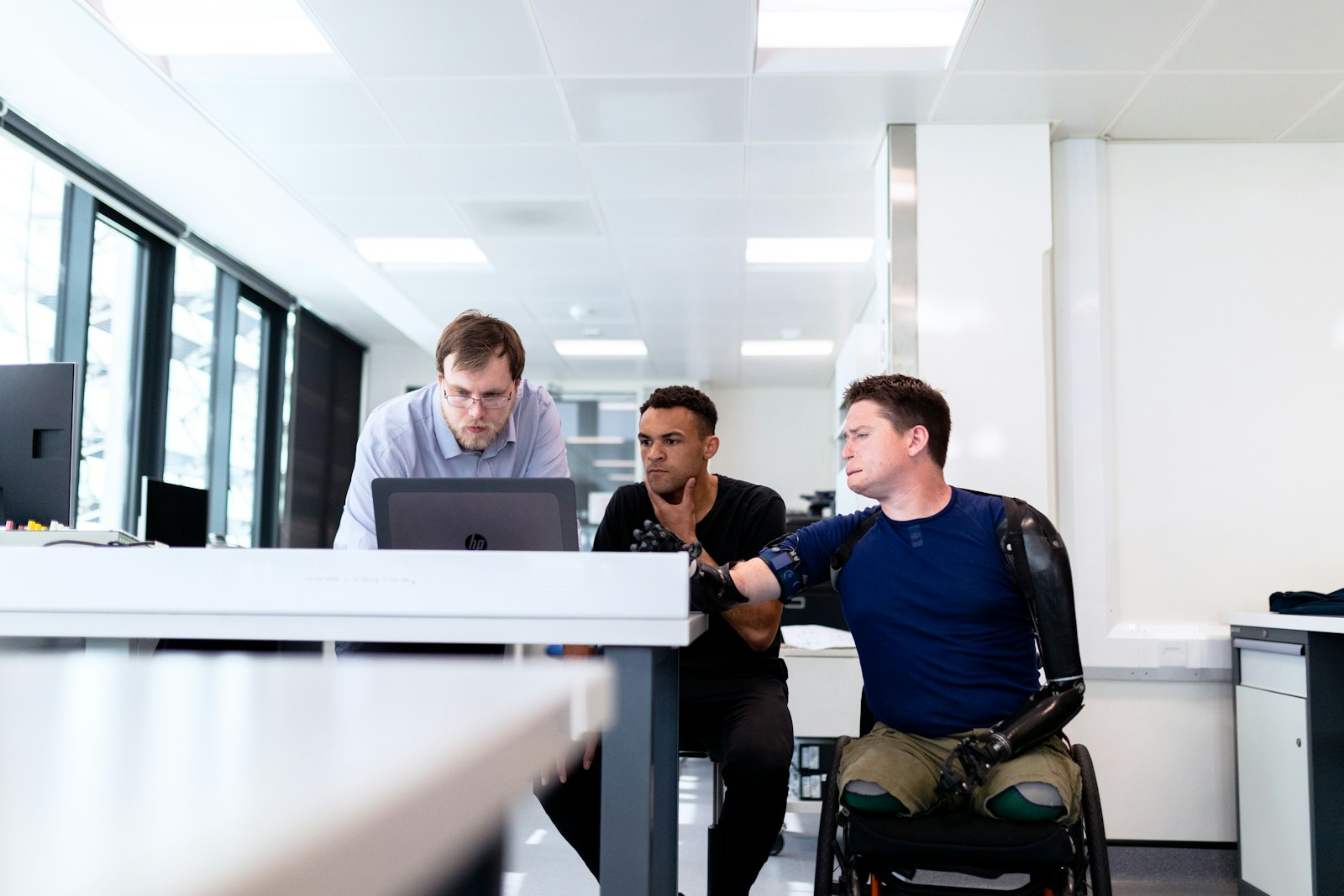 man in blue dress shirt sitting on black office rolling chair, group disability